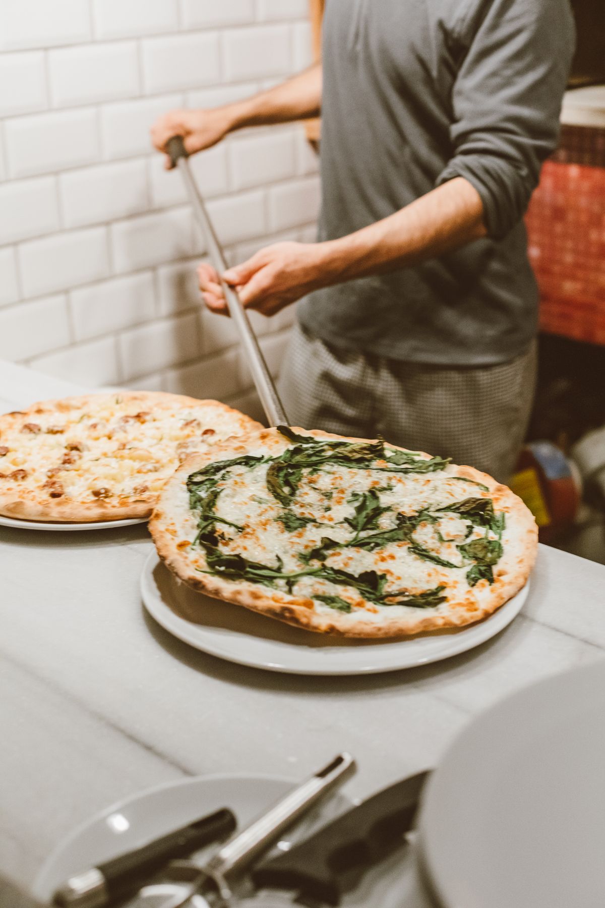 Waitress serving fresh pizza in a cozy restaurant